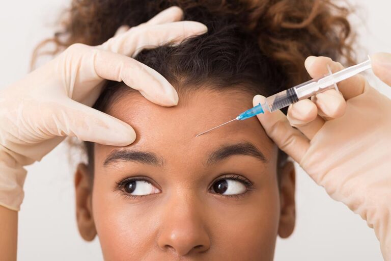 African american woman getting botox injection in forehead