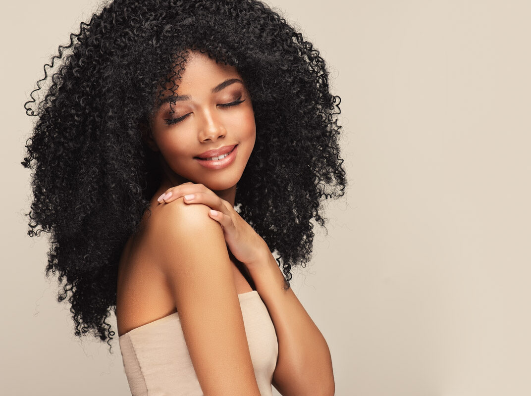 Botox An African'American woman with curly hair smiles